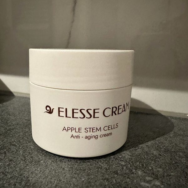 Fehér Elesse Cream tégely Apple Stem Cells felirattal, sötét kőlapon